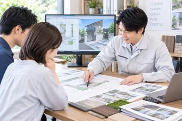 図面や素材のサンプルを見ながら外構プランを打ち合わせるイメージ